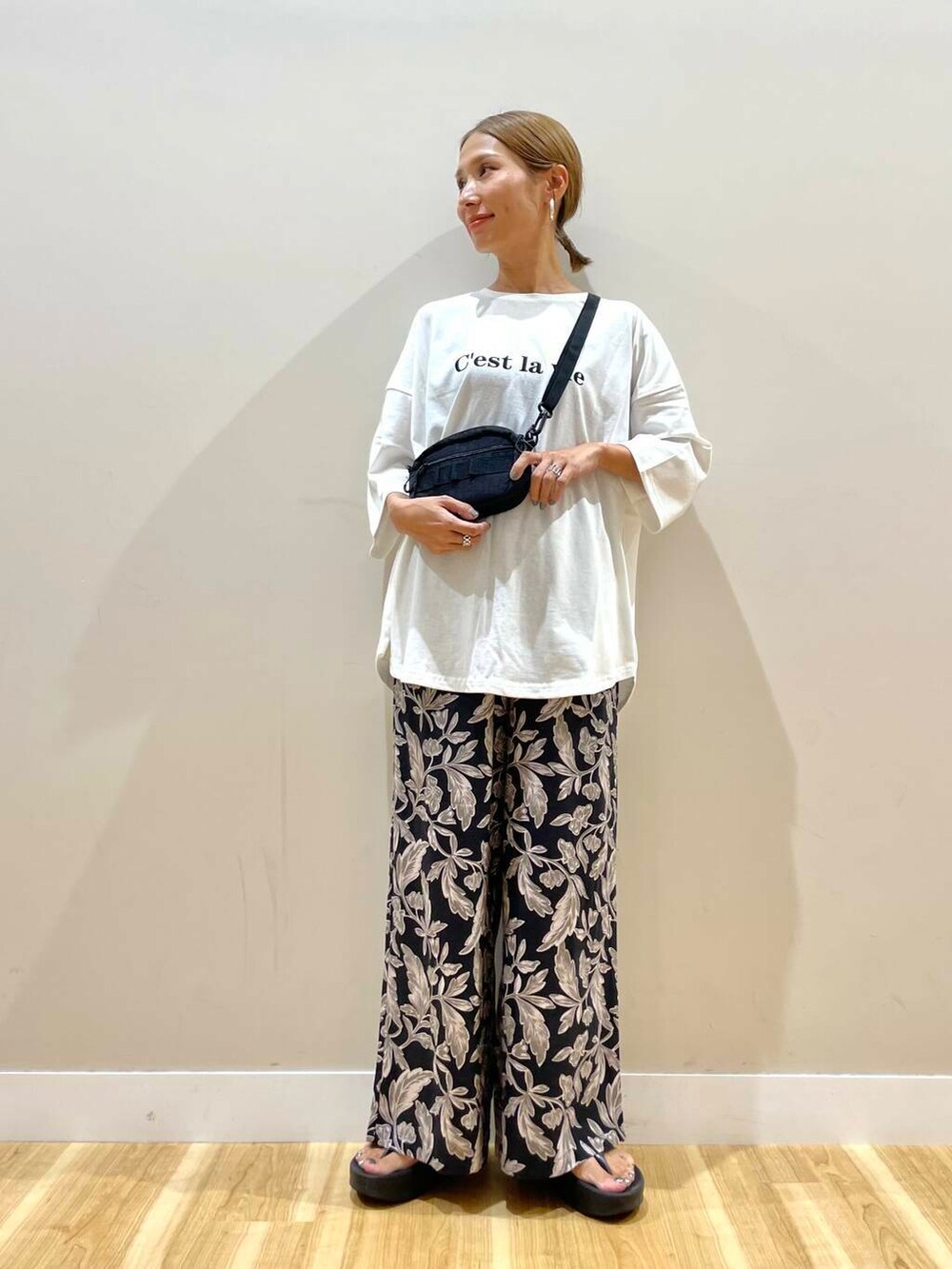 ブラック系のショルダーバッグ、ブラック系のその他パンツ、ホワイト系のTシャツ/カットソーを着用したレディースの夏コーディネートの5枚目の写真