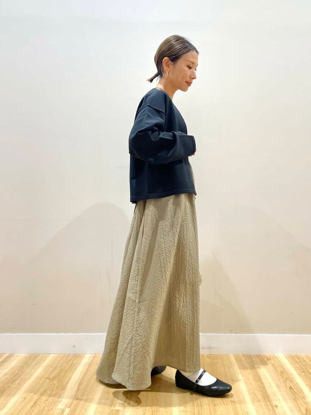 ブラック系のパンプス、ゴールド系のハンドバッグ、ブラック系のタンクトップを着用したレディースの秋コーディネートの3枚目の写真