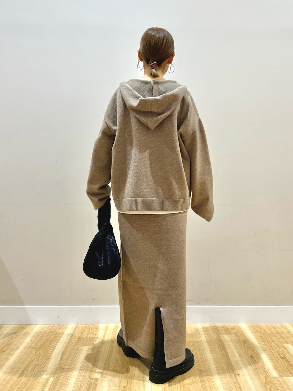 ベージュ系のニット/セーター、ホワイト系のTシャツ/カットソー、ホワイト系のダウンジャケット/コートを着用したレディースの秋コーディネートの6枚目の写真