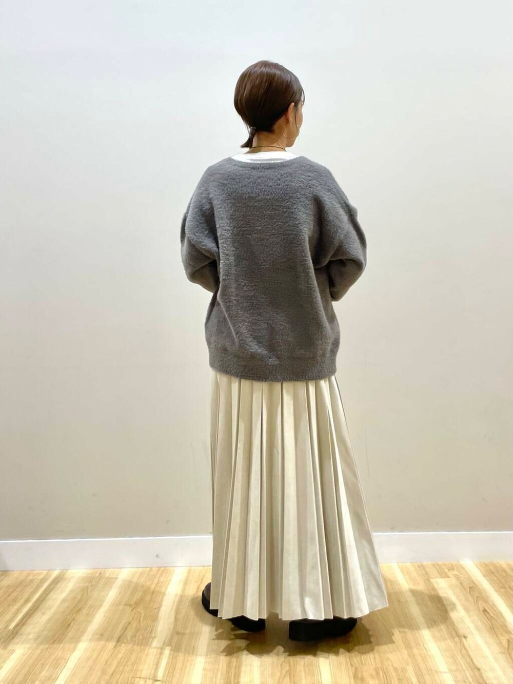 ベージュ系のスカート、ブラック系のブーツ、グレー系のダウンジャケット/コートを着用したレディースの冬コーディネートの9枚目の写真