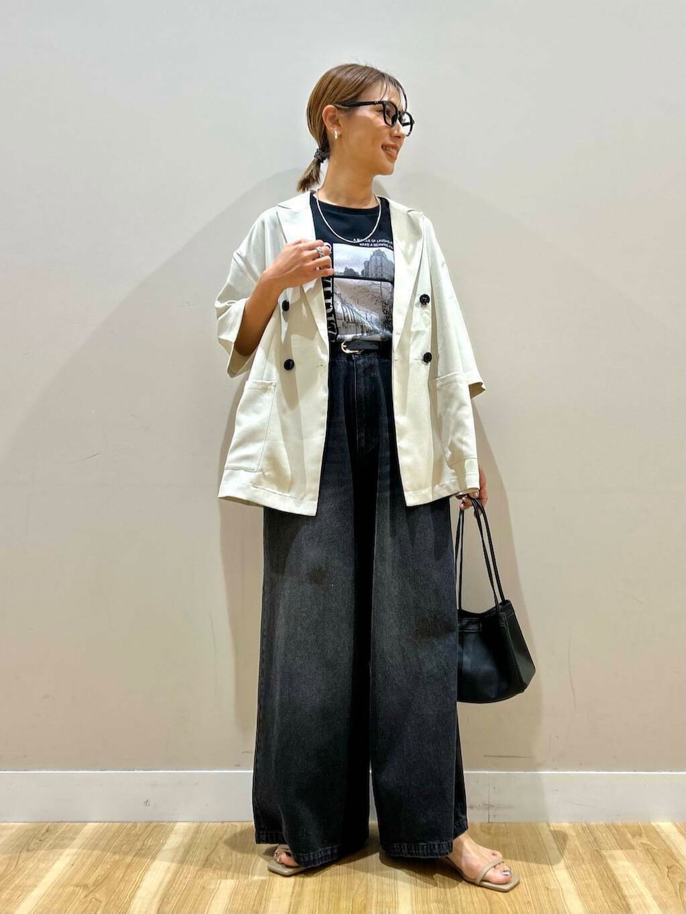 グレー系のサンダル、ブラック系のデニムパンツ、ベージュ系のその他アウターを着用したレディースの春コーディネートの2枚目の写真