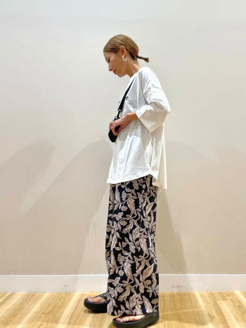 ブラック系のショルダーバッグ、ブラック系のその他パンツ、ホワイト系のTシャツ/カットソーを着用したレディースの夏コーディネートの4枚目の写真