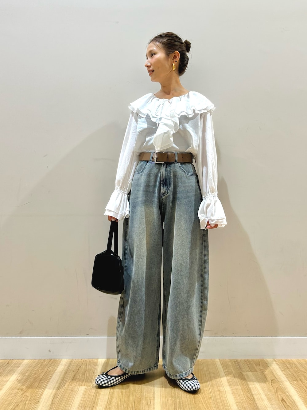 ホワイト系のシャツ/ブラウス、ブルー系のデニムパンツ、ブラック系のトートバッグを着用したレディースの春コーディネートの2枚目の写真