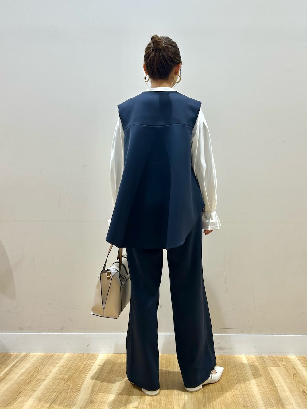 ブルー系のセットアップ、ホワイト系のシャツ/ブラウス、ベージュ系のトートバッグを着用したレディースの春コーディネートの3枚目の写真