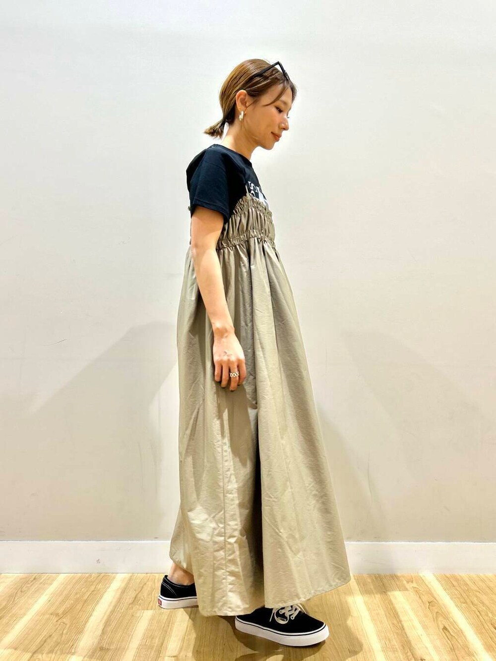 ブラック系のスニーカー、ブラック系のトートバッグ、ベージュ系のワンピースを着用したレディースの春コーディネートの5枚目の写真