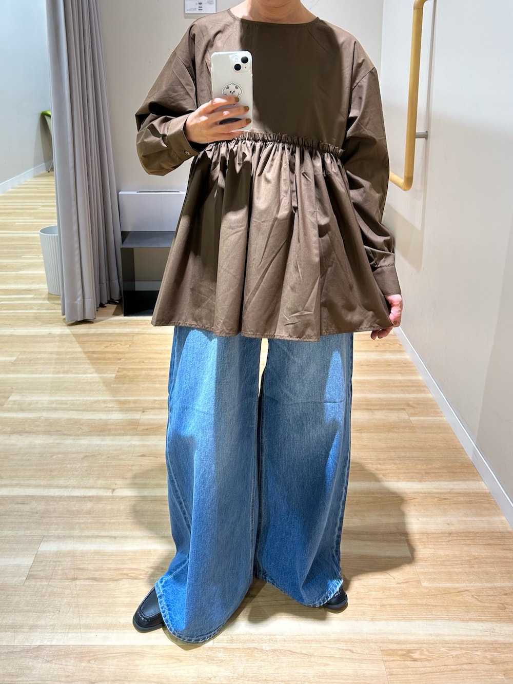 ブラウン系のシャツ/ブラウス、ブルー系のデニムパンツ、ブラック系のショルダーバッグを着用したレディースの秋コーディネートの6枚目の写真