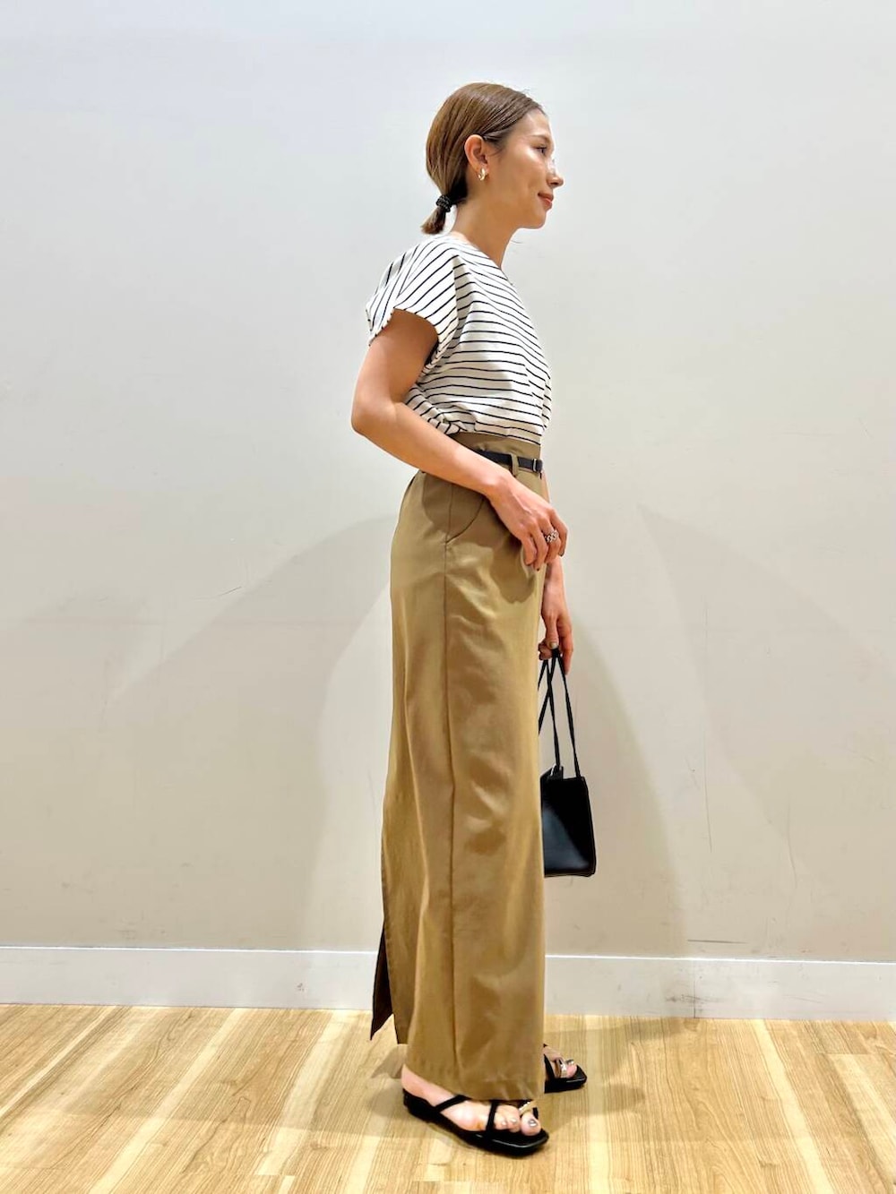 ホワイト系のTシャツ/カットソー、ブラック系のハンドバッグ、イエロー系のスカートを着用したレディースの夏コーディネートの4枚目の写真