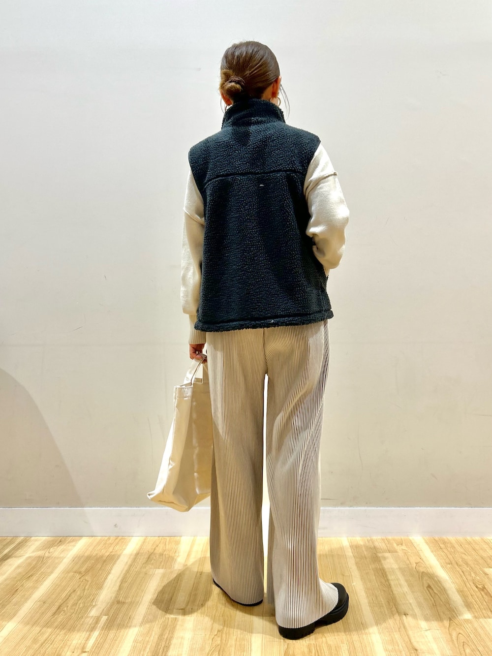 グレー系のベスト、グリーン系のダウンジャケット/コート、ホワイト系のニット/セーターを着用したレディースの冬コーディネートの6枚目の写真