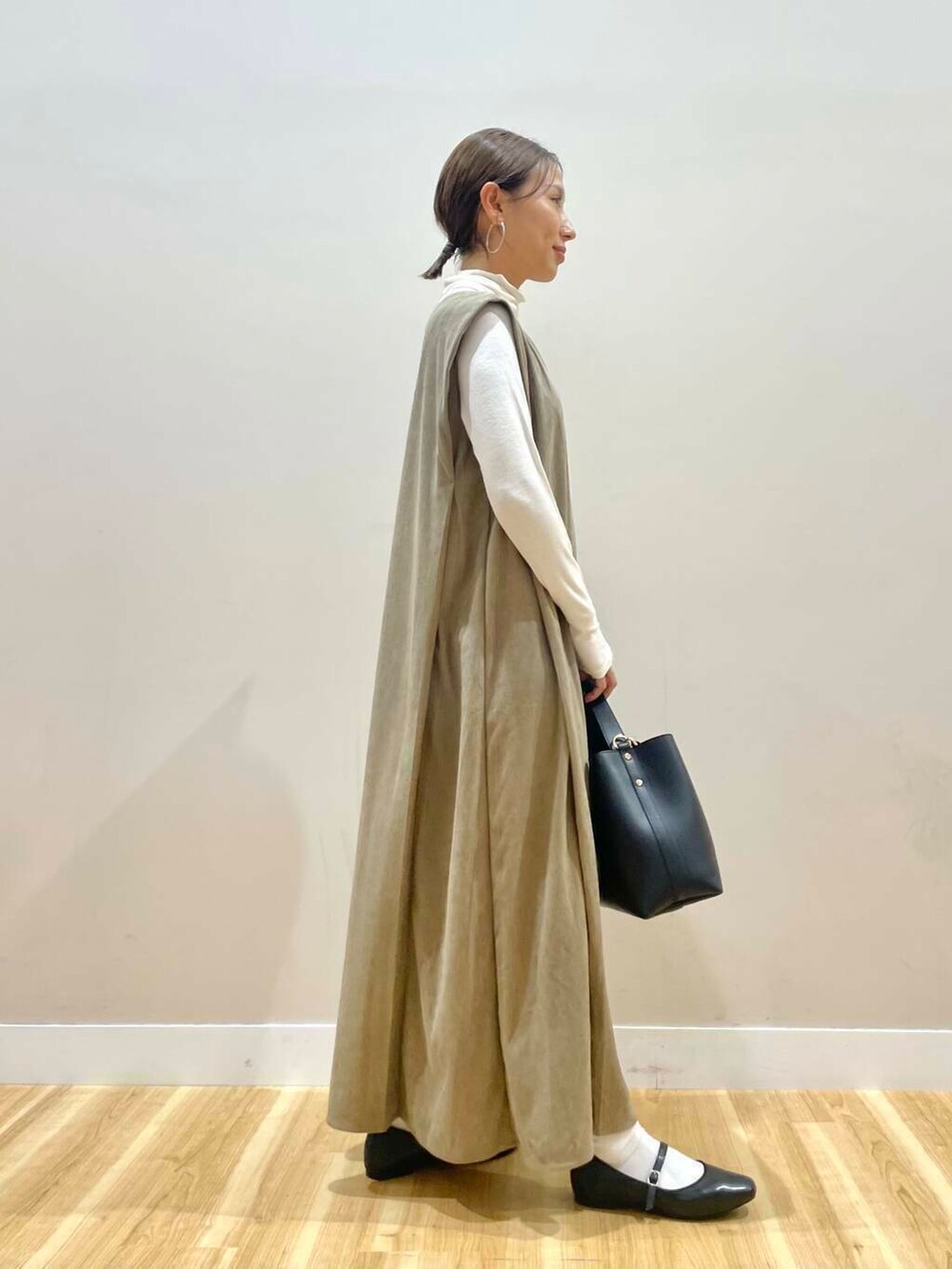 ブラック系のパンプス、ブラック系のトートバッグ、ホワイト系のTシャツ/カットソーを着用したレディースの秋コーディネートの2枚目の写真