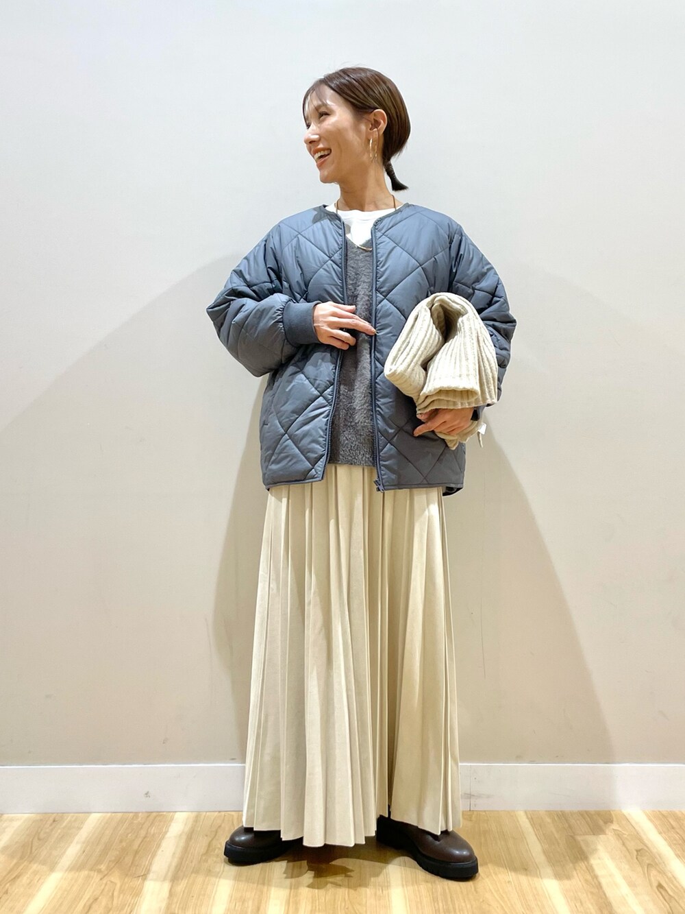 グレー系のニット/セーター、グレー系のダウンジャケット/コート、ホワイト系のTシャツ/カットソーを着用したレディースの冬コーディネートの8枚目の写真