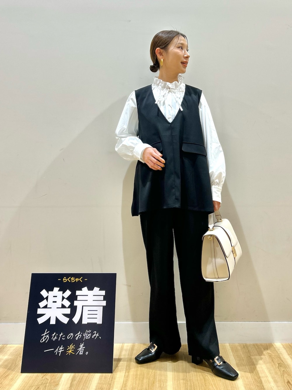 ブラック系のセットアップ、ホワイト系のシャツ/ブラウス、ホワイト系のハンドバッグを着用したレディースの春コーディネートの4枚目の写真