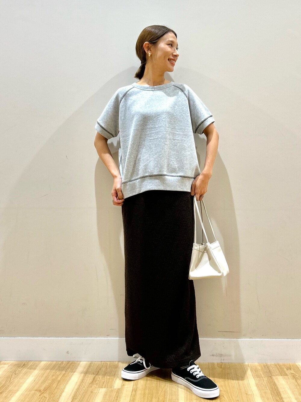 ホワイト系のブルゾン、グレー系のスウェット、ブラウン系のスカートを着用したレディースの秋コーディネートの4枚目の写真