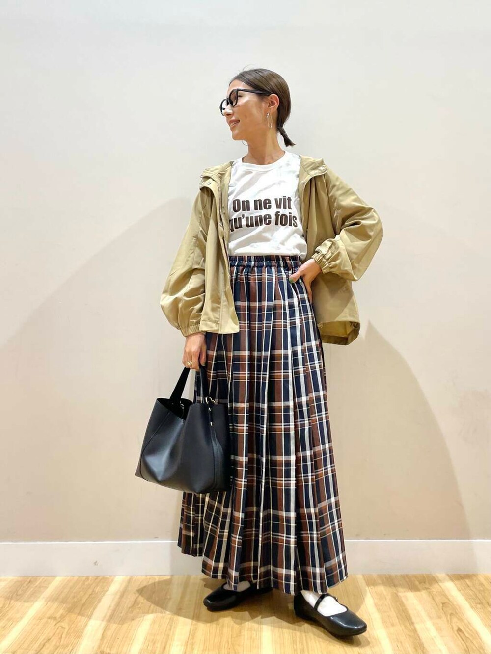 ブラック系のパンプス、ブラック系のトートバッグ、ブルー系のスカートを着用したレディースの秋コーディネートの5枚目の写真