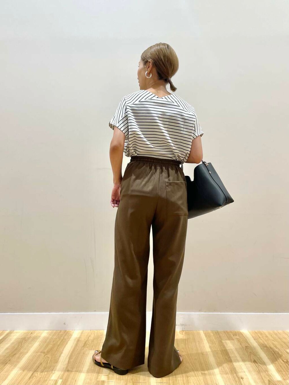 ブラウン系のサンダル、ホワイト系のTシャツ/カットソー、ブラック系のトートバッグを着用したレディースの夏コーディネートの3枚目の写真