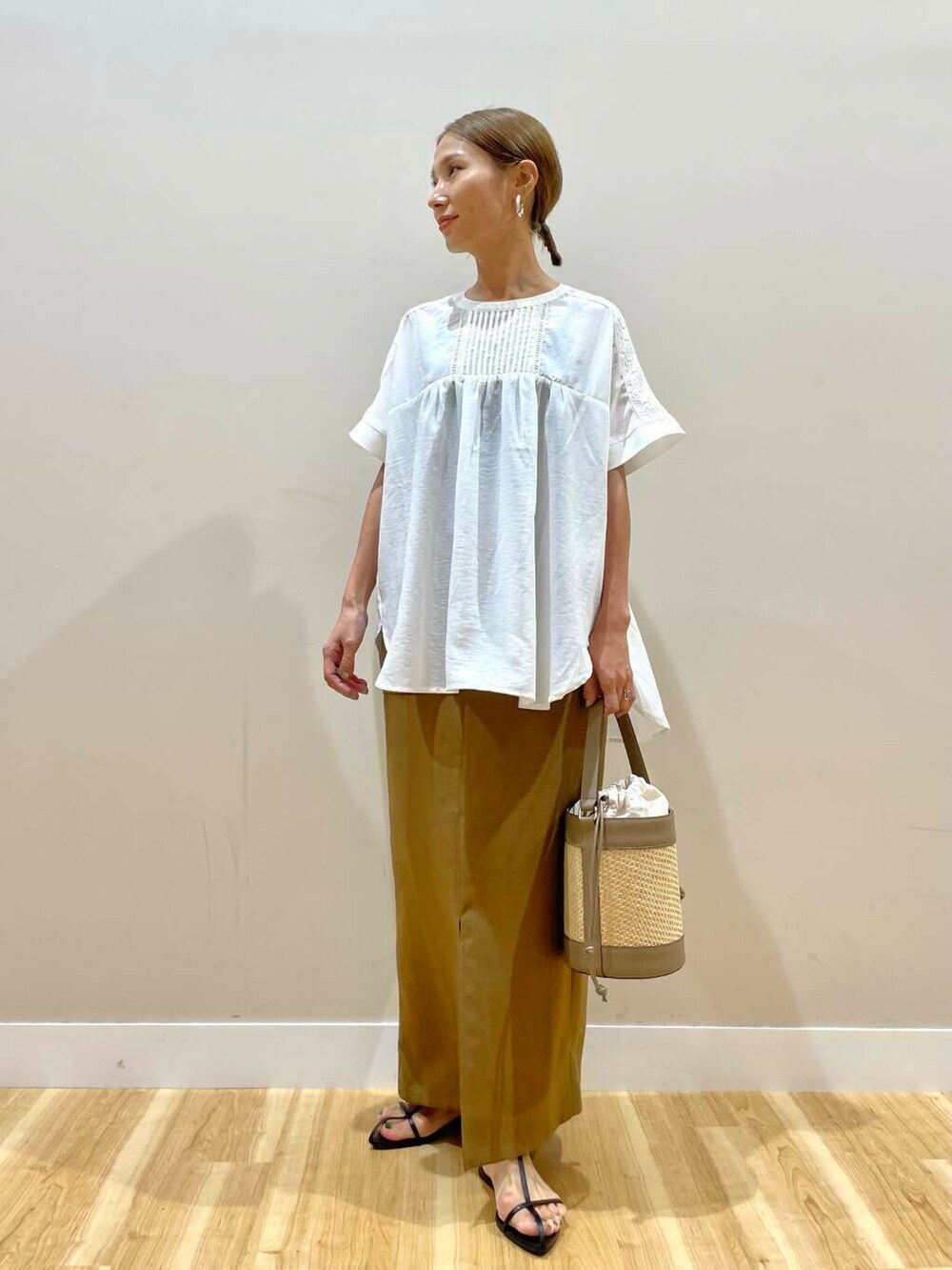 ホワイト系のシャツ/ブラウス、グレー系のショルダーバッグ、イエロー系のスカートを着用したレディースの夏コーディネートの5枚目の写真