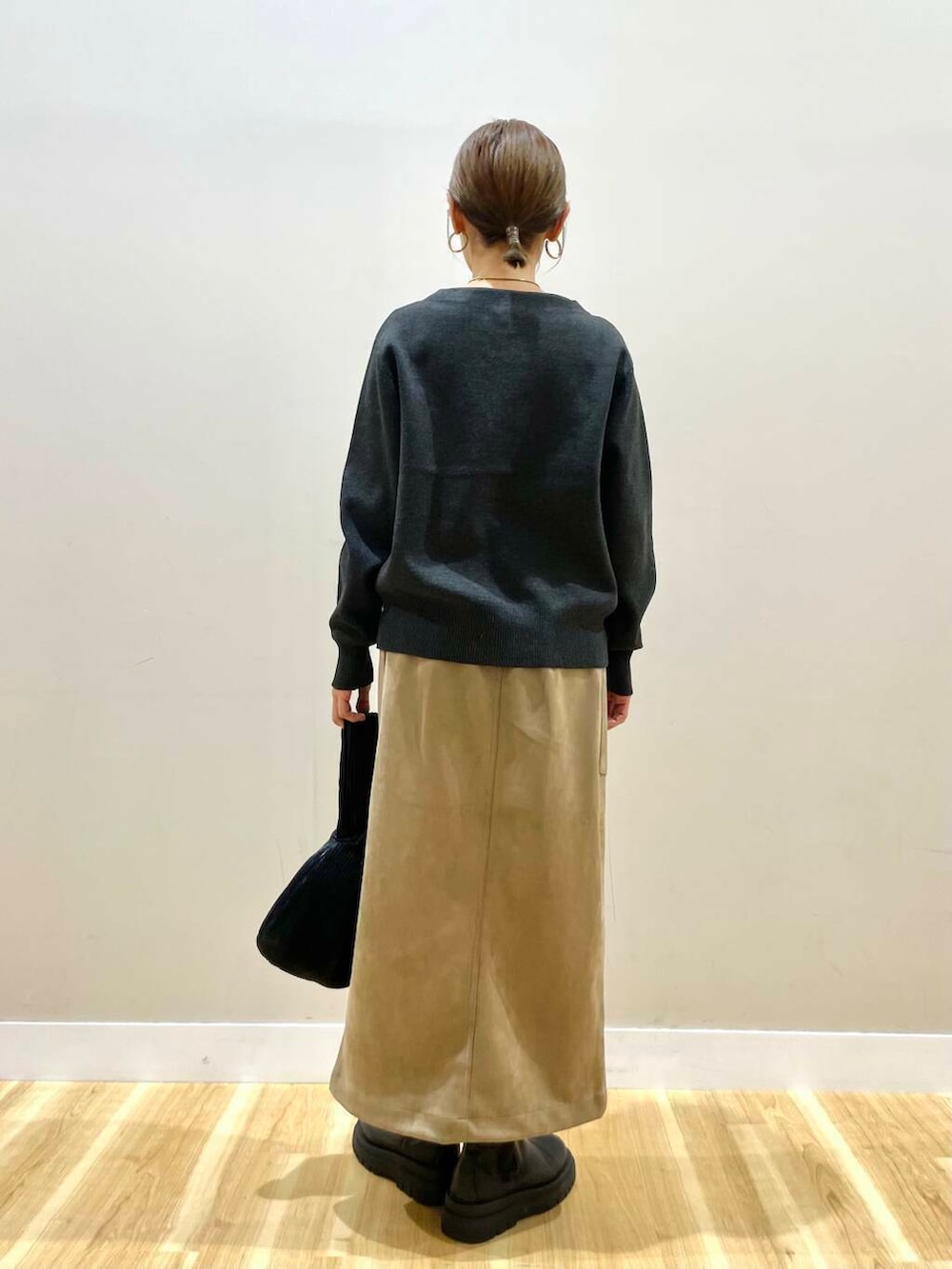 ブラウン系のスカート、ブラック系のハンドバッグ、グレー系のニット/セーターを着用したレディースの冬コーディネートの7枚目の写真