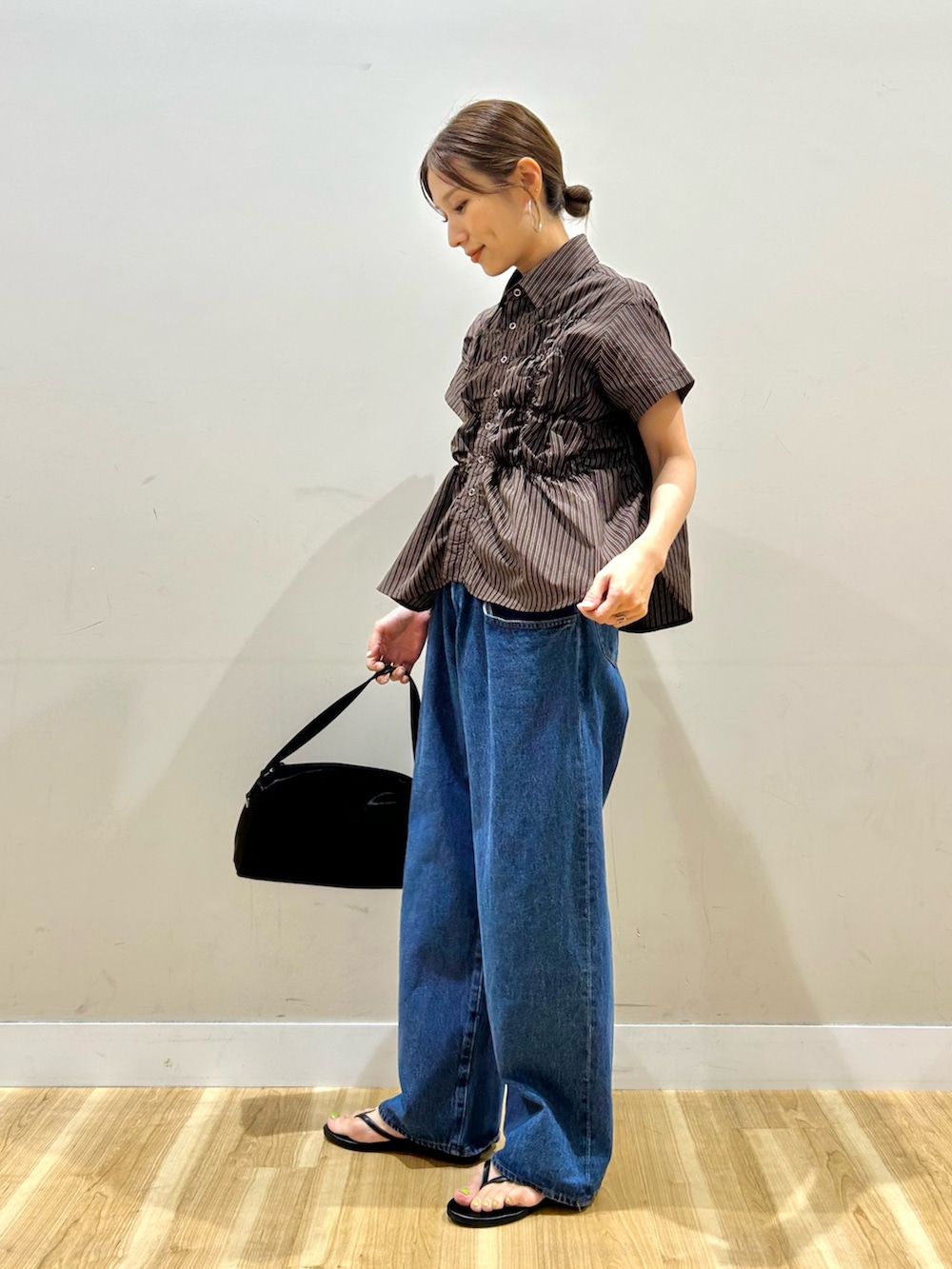 ブラウン系のシャツ/ブラウス、ブルー系のデニムパンツ、ブラック系のトートバッグを着用したレディースの夏コーディネートの4枚目の写真