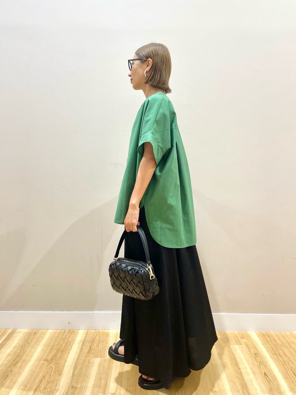 グリーン系のシャツ/ブラウス、ブラック系のワンピース、ブルー系のデニムパンツを着用したレディースの夏コーディネートの4枚目の写真