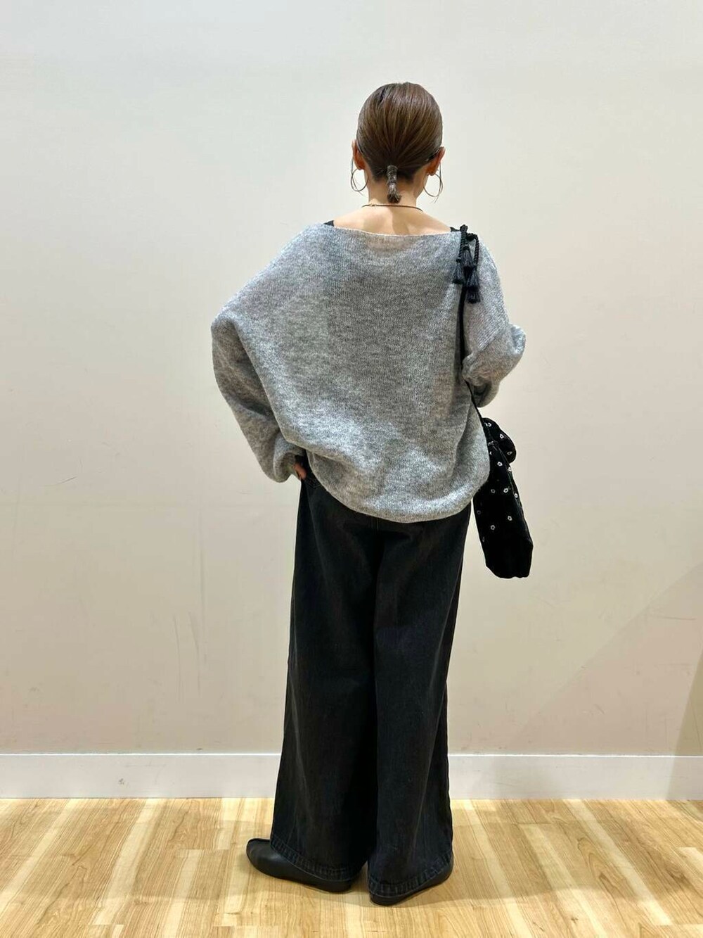 ブラック系のショルダーバッグ、ブラック系のデニムパンツ、グレー系のニット/セーターを着用したレディースの春コーディネートの3枚目の写真