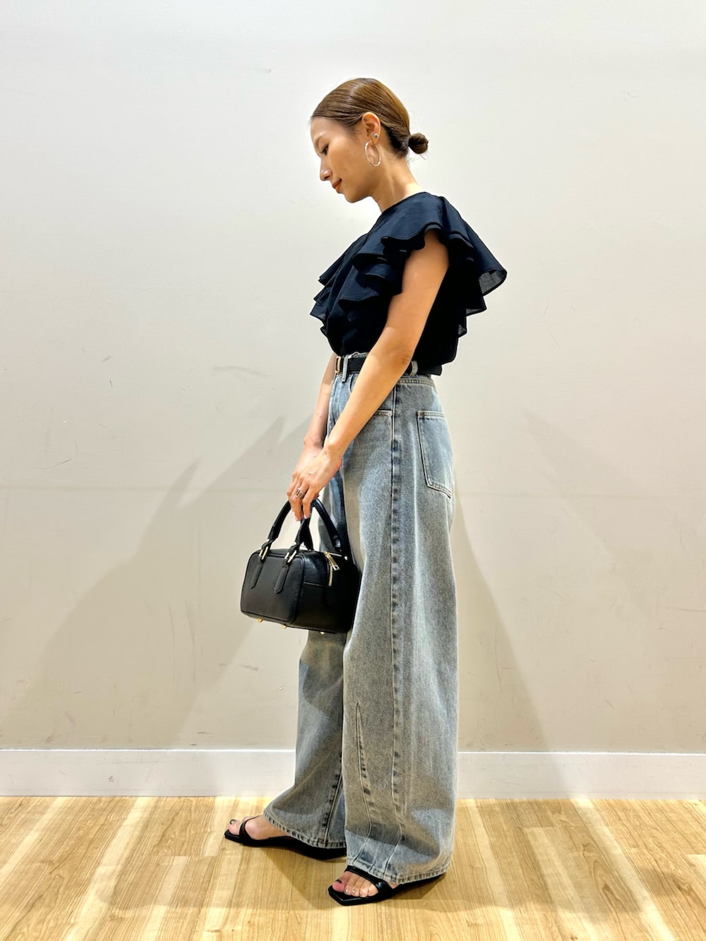 ブラック系のシャツ/ブラウス、ブルー系のデニムパンツ、ブラック系のサンダルを着用したレディースの夏コーディネートの2枚目の写真