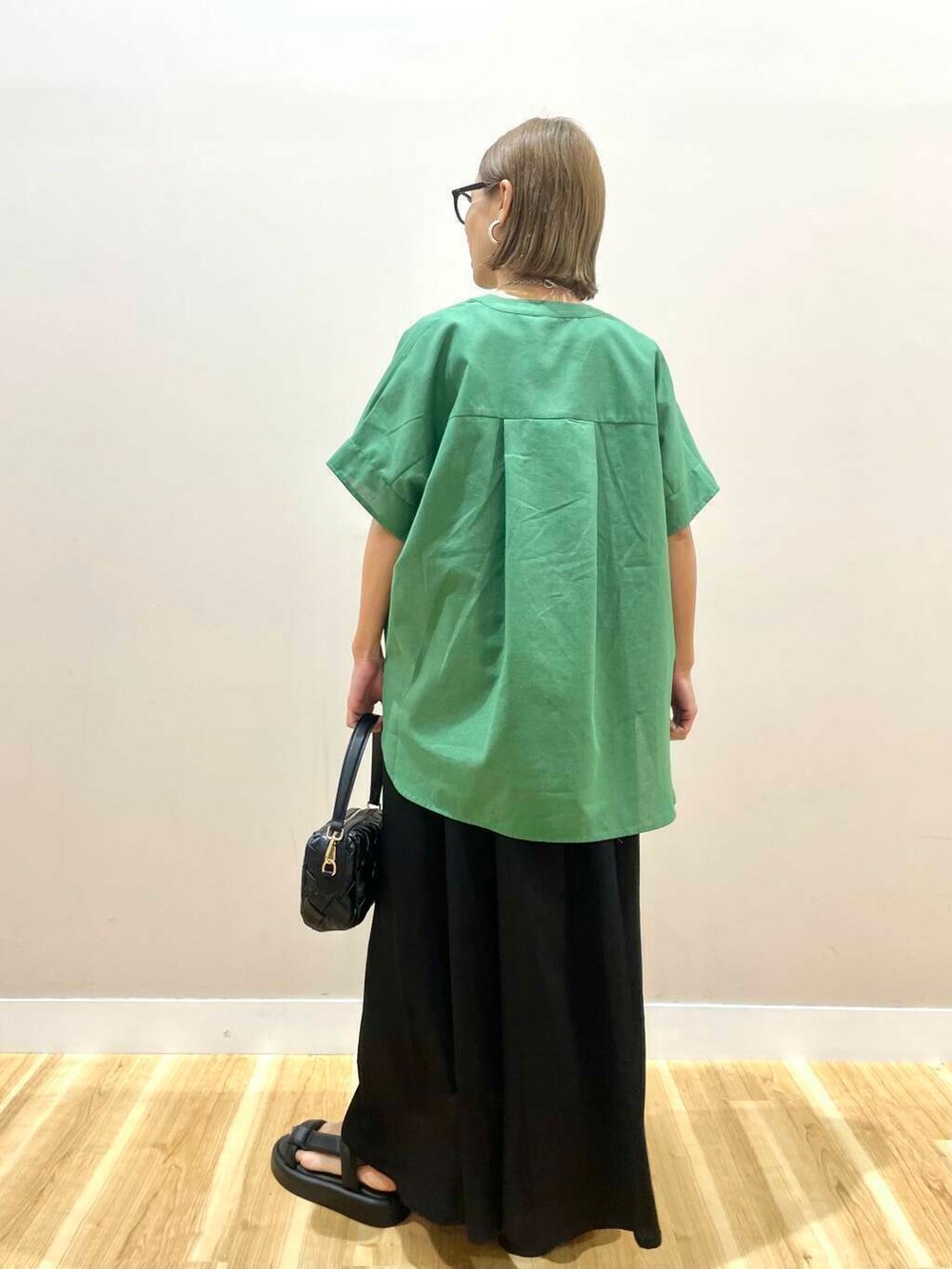 ホワイト系のタンクトップ、ブラック系のサンダル、ブラック系のショルダーバッグを着用したレディースの夏コーディネートの3枚目の写真