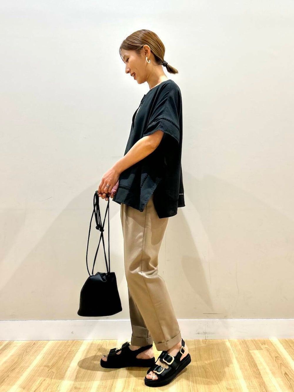 ブラック系のサンダル、ブラウン系のその他パンツ、ブラック系のショルダーバッグを着用したレディースの春コーディネートの2枚目の写真