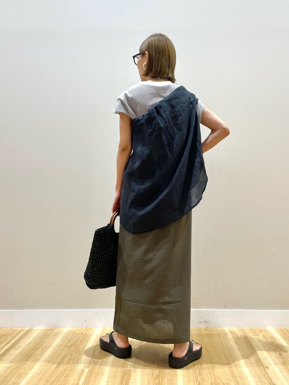 ブラウン系のTシャツ/カットソー、ブラウン系のスカート、ブラック系のかごバッグを着用したレディースの夏コーディネートの3枚目の写真