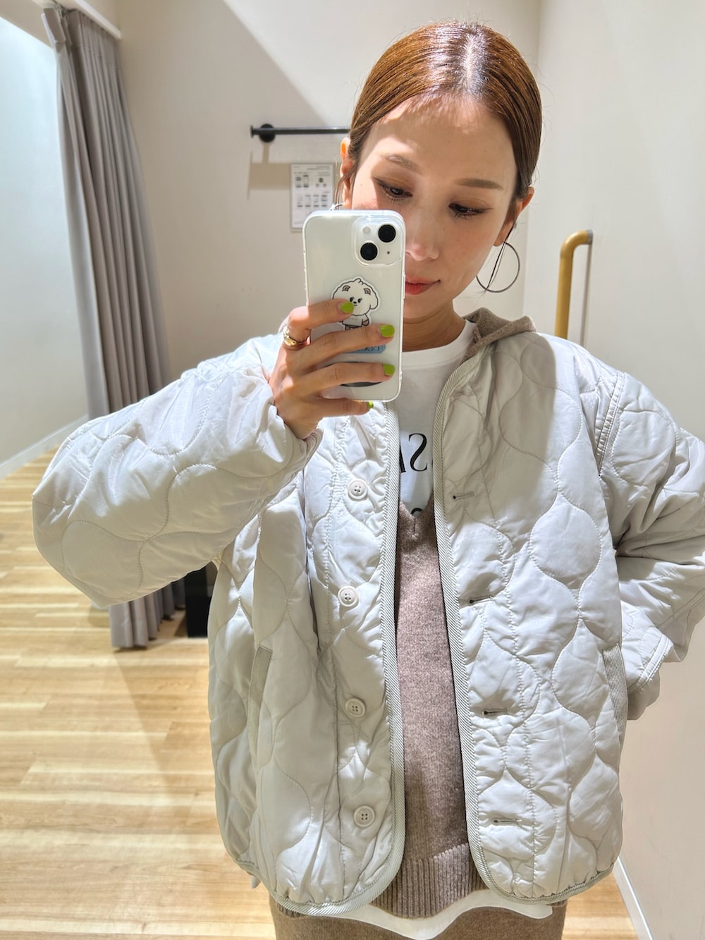 ベージュ系のニット/セーター、ホワイト系のTシャツ/カットソー、ホワイト系のダウンジャケット/コートを着用したレディースの秋コーディネートの7枚目の写真