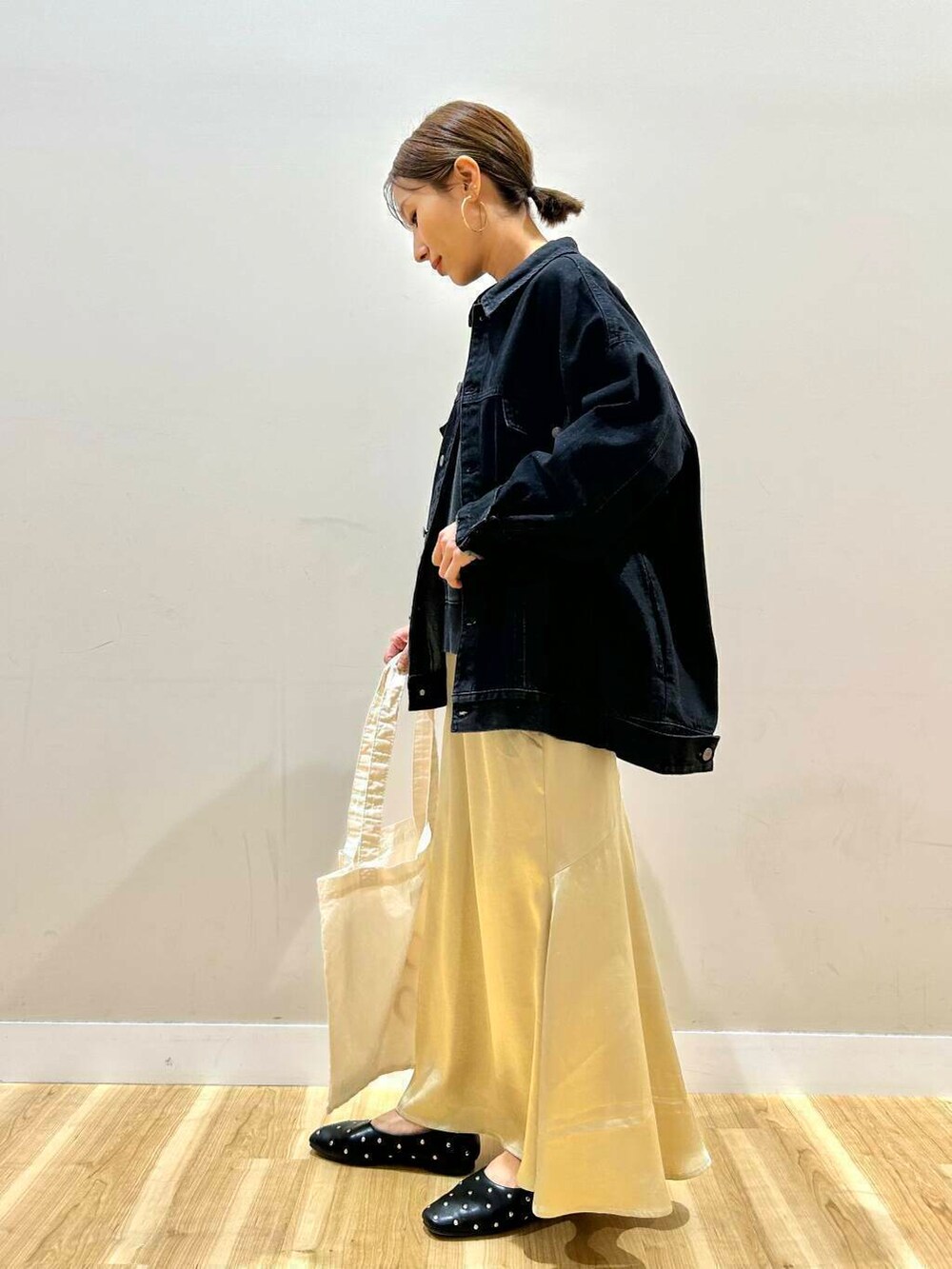 ブラック系のパンプス、ホワイト系のトートバッグ、ブラック系のデニムジャケットを着用したレディースの冬コーディネートの2枚目の写真