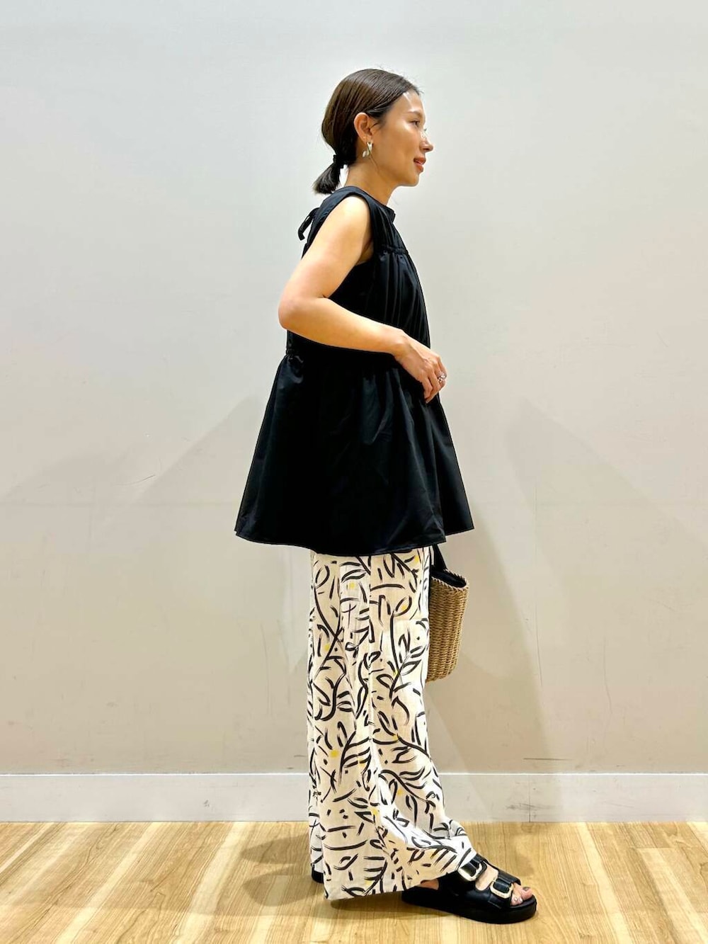 ホワイト系のその他パンツ、ベージュ系のハンドバッグ、ブラック系のサンダルを着用したレディースの夏コーディネートの4枚目の写真