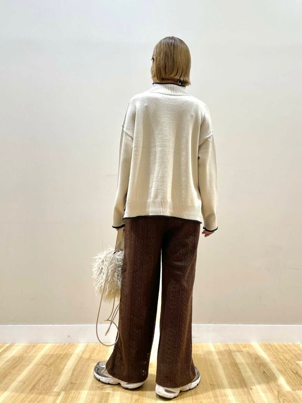 ベージュ系のショルダーバッグ、ホワイト系のニット/セーター、ブラウン系のその他パンツを着用したレディースの秋コーディネートの3枚目の写真