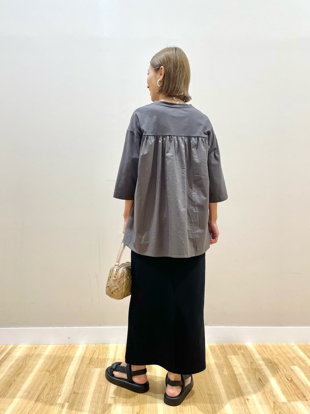 グレー系のTシャツ/カットソー、ブラック系のスカート、ブルー系のデニムパンツを着用したレディースの夏コーディネートの3枚目の写真