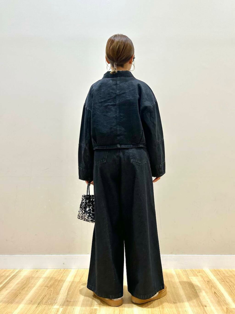 ホワイト系のニット/セーター、シルバー系のショルダーバッグ、ブラック系のデニムパンツを着用したレディースの冬コーディネートの3枚目の写真