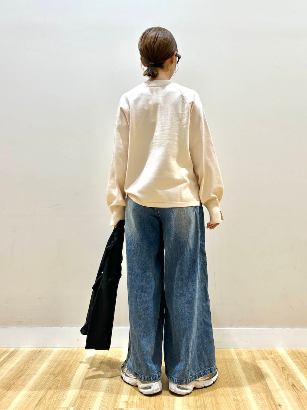 ホワイト系のニット/セーター、ブルー系のデニムパンツ、ブラック系のトートバッグを着用したレディースの春コーディネートの8枚目の写真