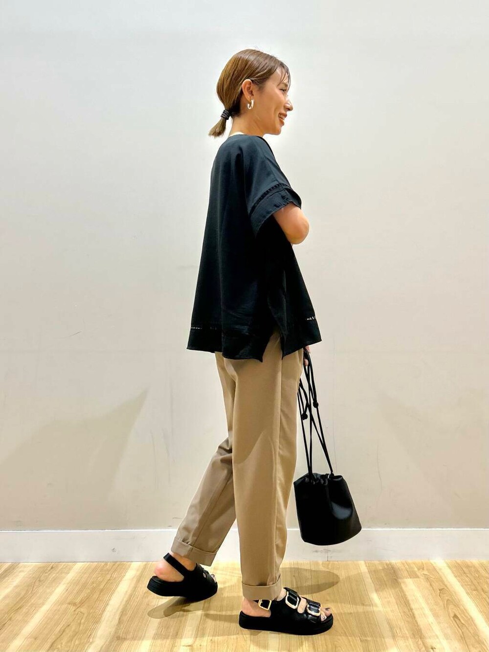 ブラック系のサンダル、ブラウン系のその他パンツ、ブラック系のショルダーバッグを着用したレディースの春コーディネートの4枚目の写真