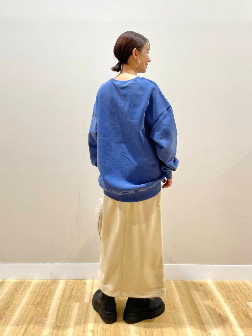 ベージュ系のショルダーバッグ、ホワイト系のスカート、グレー系のパーカーを着用したレディースの冬コーディネートの6枚目の写真