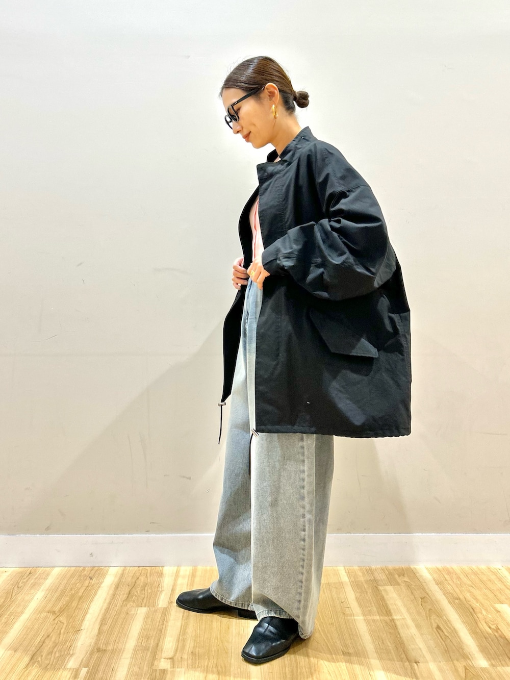 ブラック系のモッズコート、ピンク系のベスト、ピンク系のニット/セーターを着用したレディースの冬コーディネートの4枚目の写真