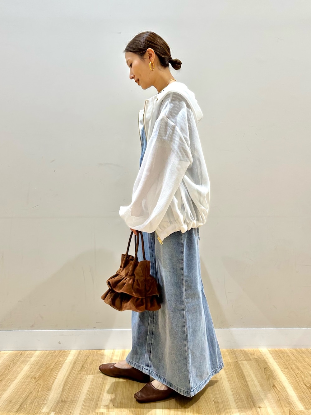 ホワイト系のマウンテンパーカー、ブラウン系のニット/セーター、ブルー系のワンピースを着用したレディースの春コーディネートの2枚目の写真