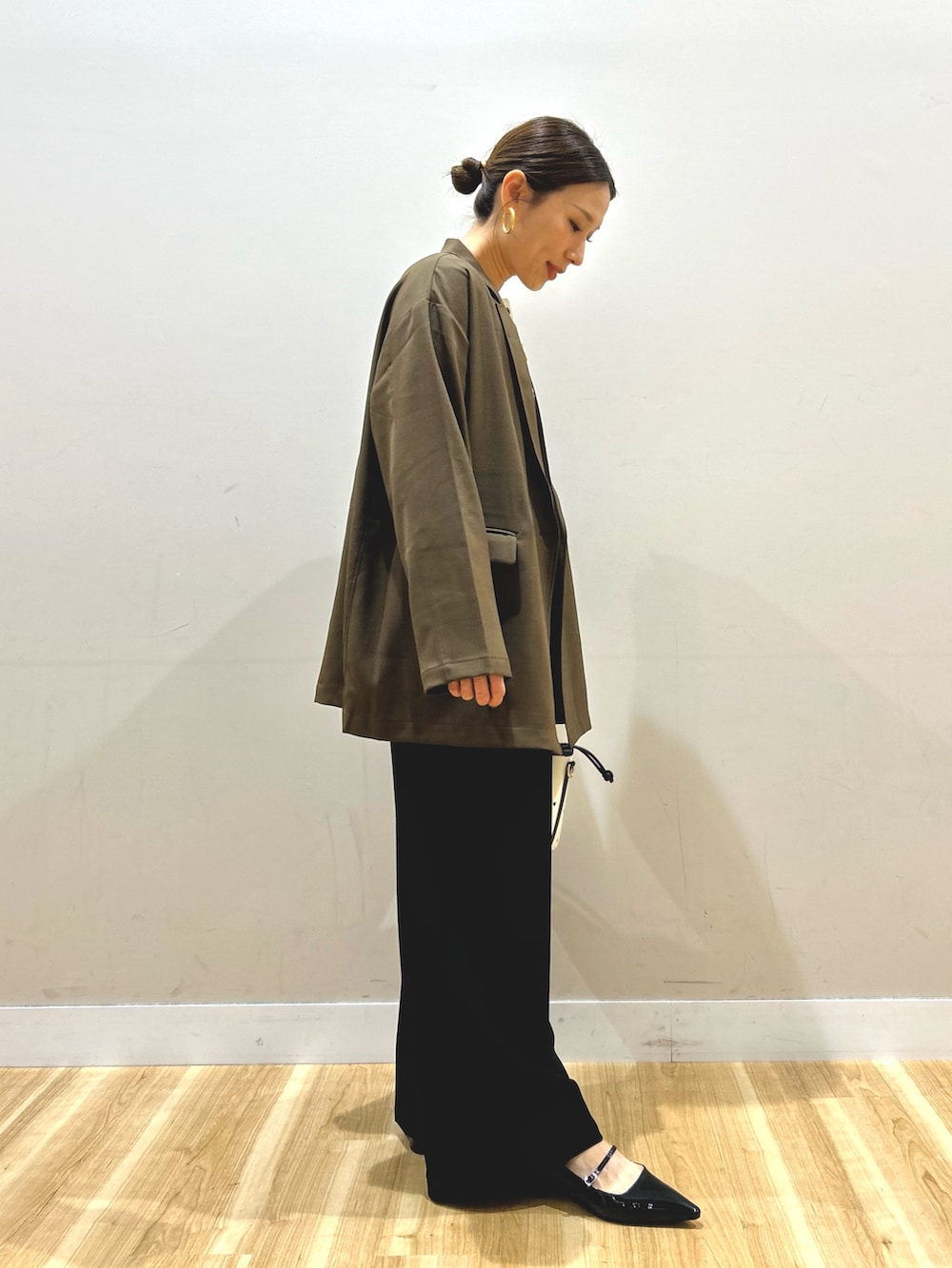 ブラウン系のその他アウター、ホワイト系のニット/セーター、ブラック系のその他パンツを着用したレディースの春コーディネートの2枚目の写真