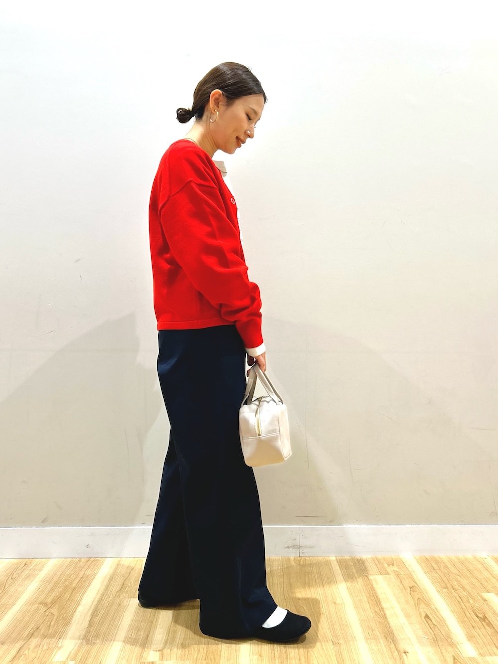 レッド系のカーディガン/ボレロ、ベージュ系のTシャツ/カットソー、ブルー系のその他パンツを着用したレディースの冬コーディネートの2枚目の写真