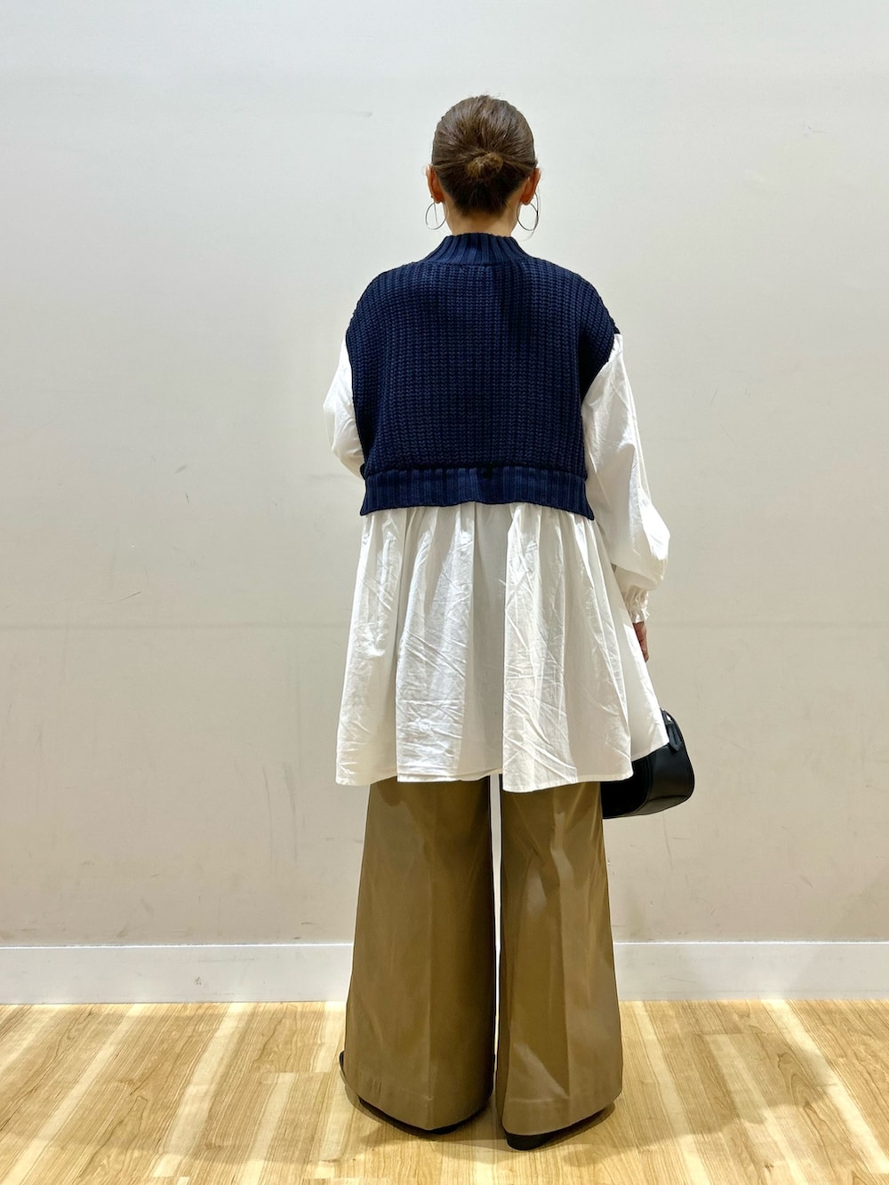 ホワイト系のシャツ/ブラウス、ベージュ系のチノパンツ、ブラック系のショルダーバッグを着用したレディースの秋コーディネートの5枚目の写真