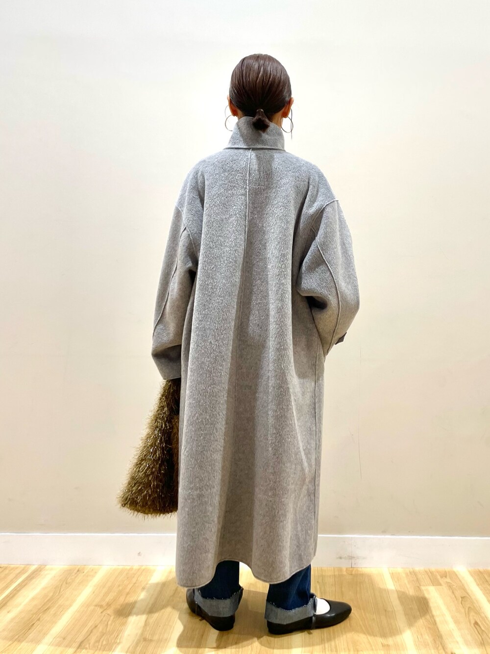 グレー系のその他アウター、ブラック系のニット/セーター、ブルー系のデニムパンツを着用したレディースの冬コーディネートの4枚目の写真