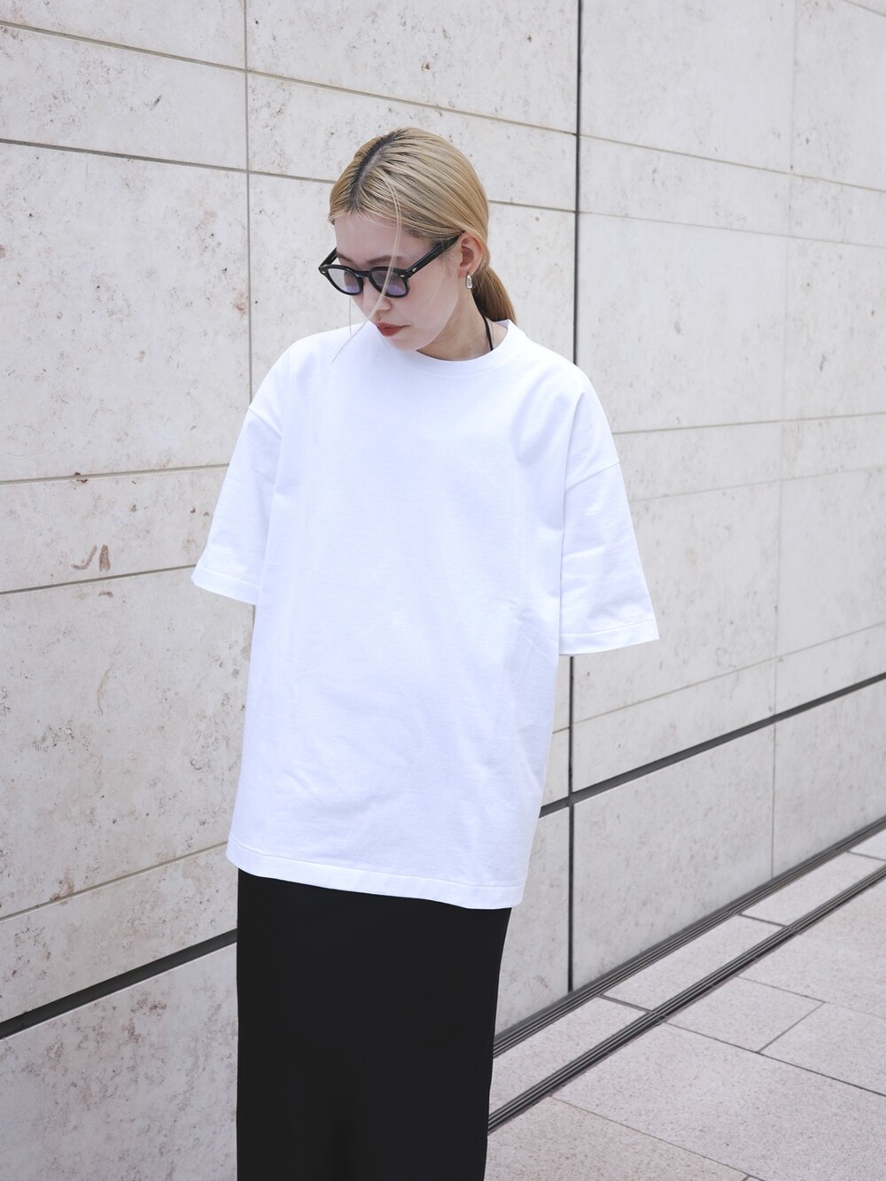 ホワイト系のTシャツ/カットソー、ブラック系のスカートを着用したレディースの夏コーディネートの2枚目の写真