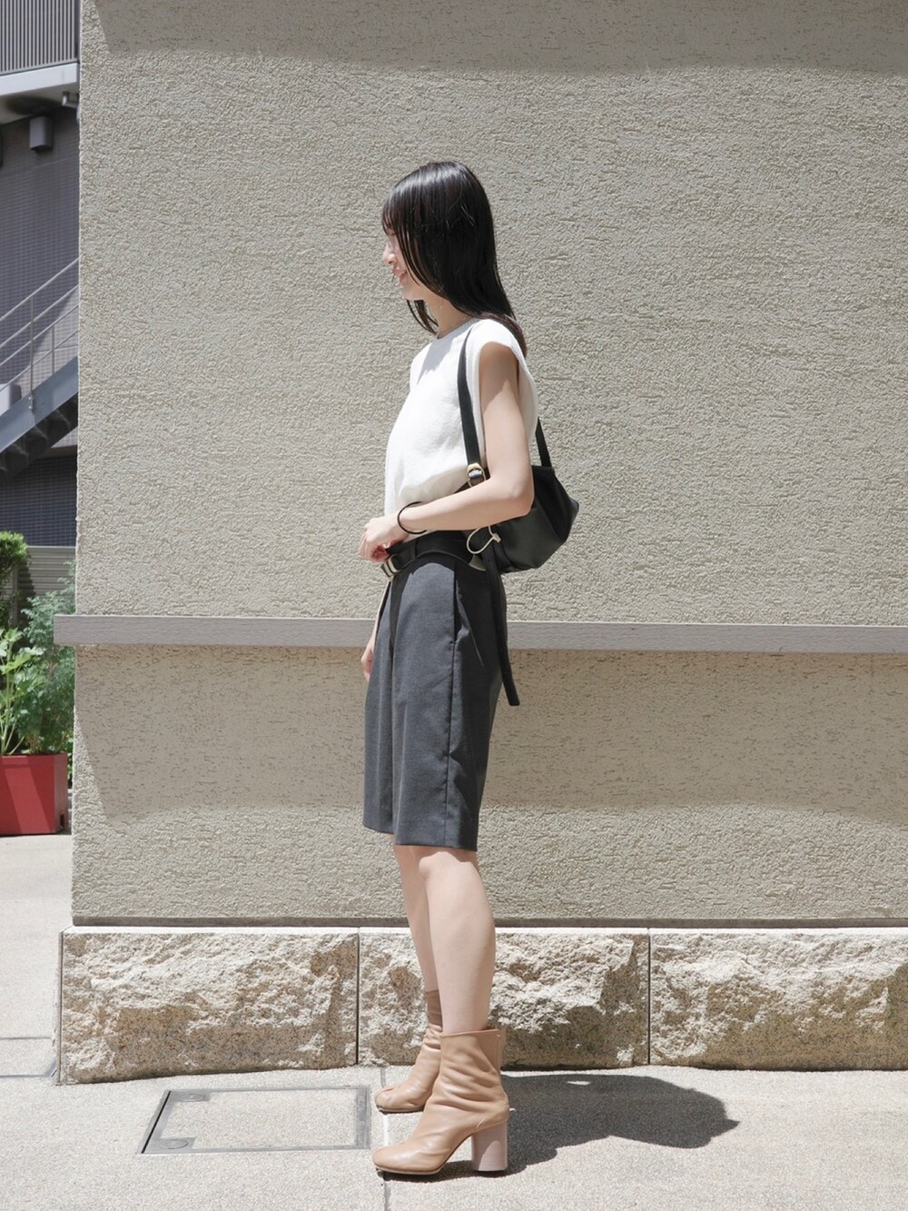 グレー系のその他パンツ、ホワイト系のニット/セーターを着用したレディースの春コーディネートの2枚目の写真