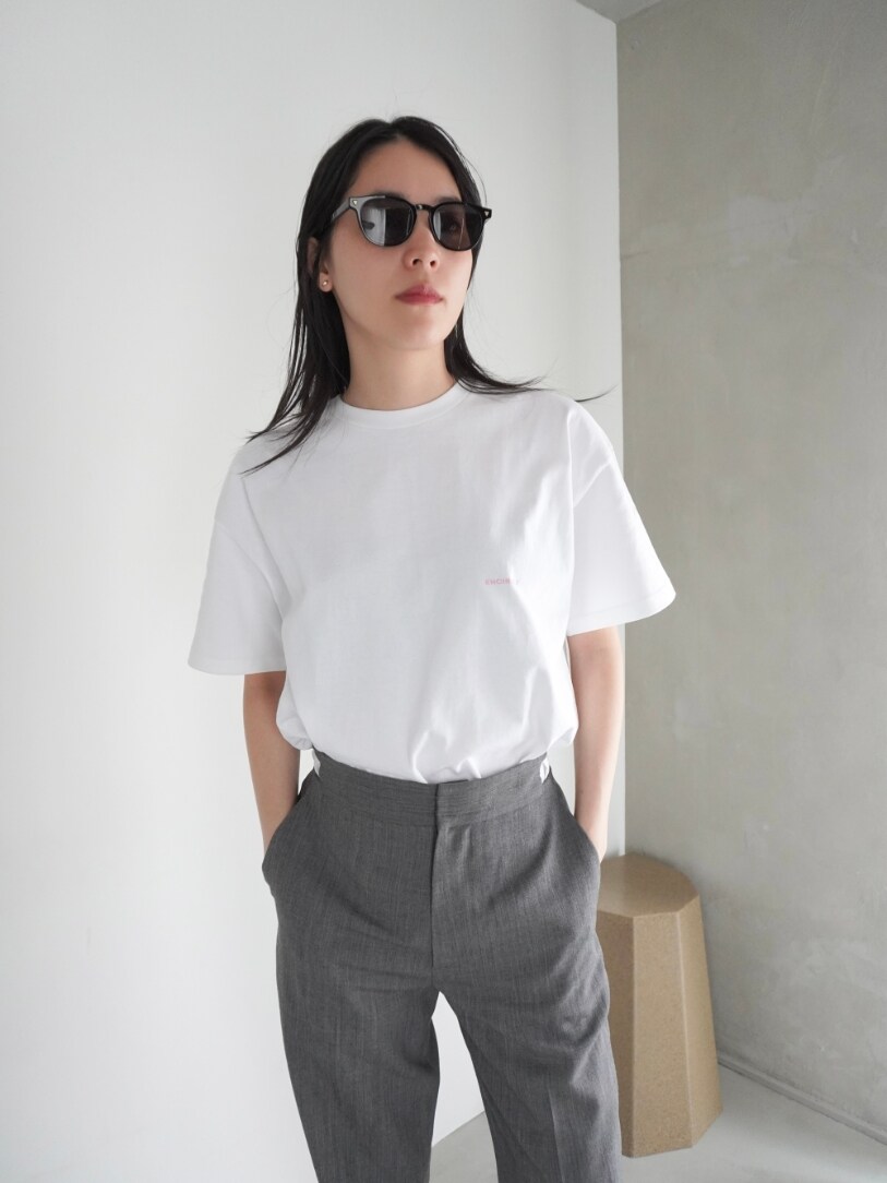 グレー系のスラックス、ピンク系のTシャツ/カットソー、ピンク系のエコバッグ/サブバッグを着用したレディースの春コーディネートの2枚目の写真