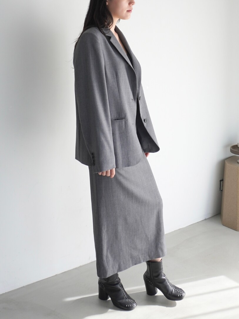 グレー系のスカート、グレー系のテーラードジャケットを着用したレディースの春コーディネートの2枚目の写真