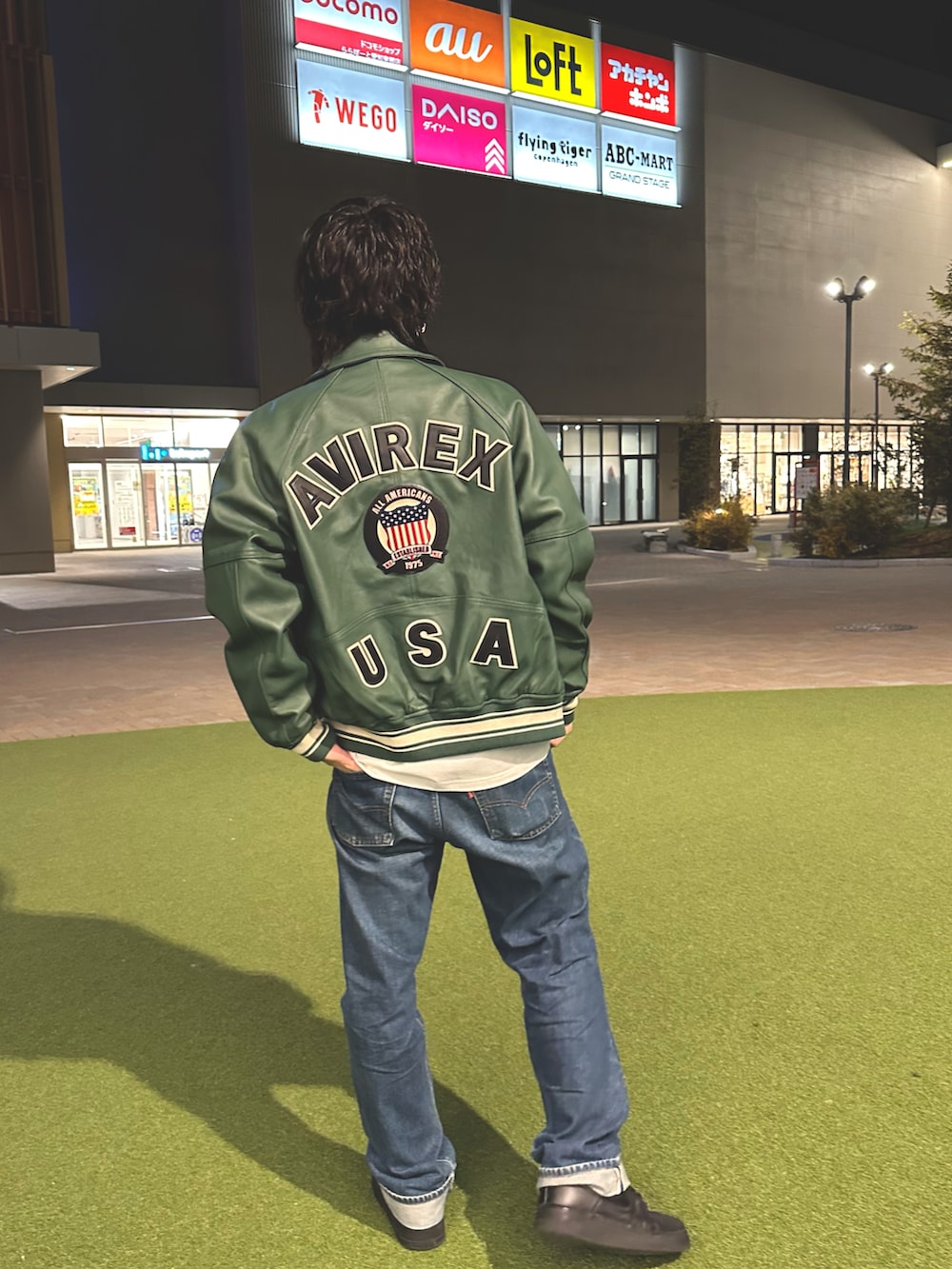 グリーン系のスタジャン、ホワイト系のTシャツ/カットソーを着用したメンズの春コーディネートの2枚目の写真