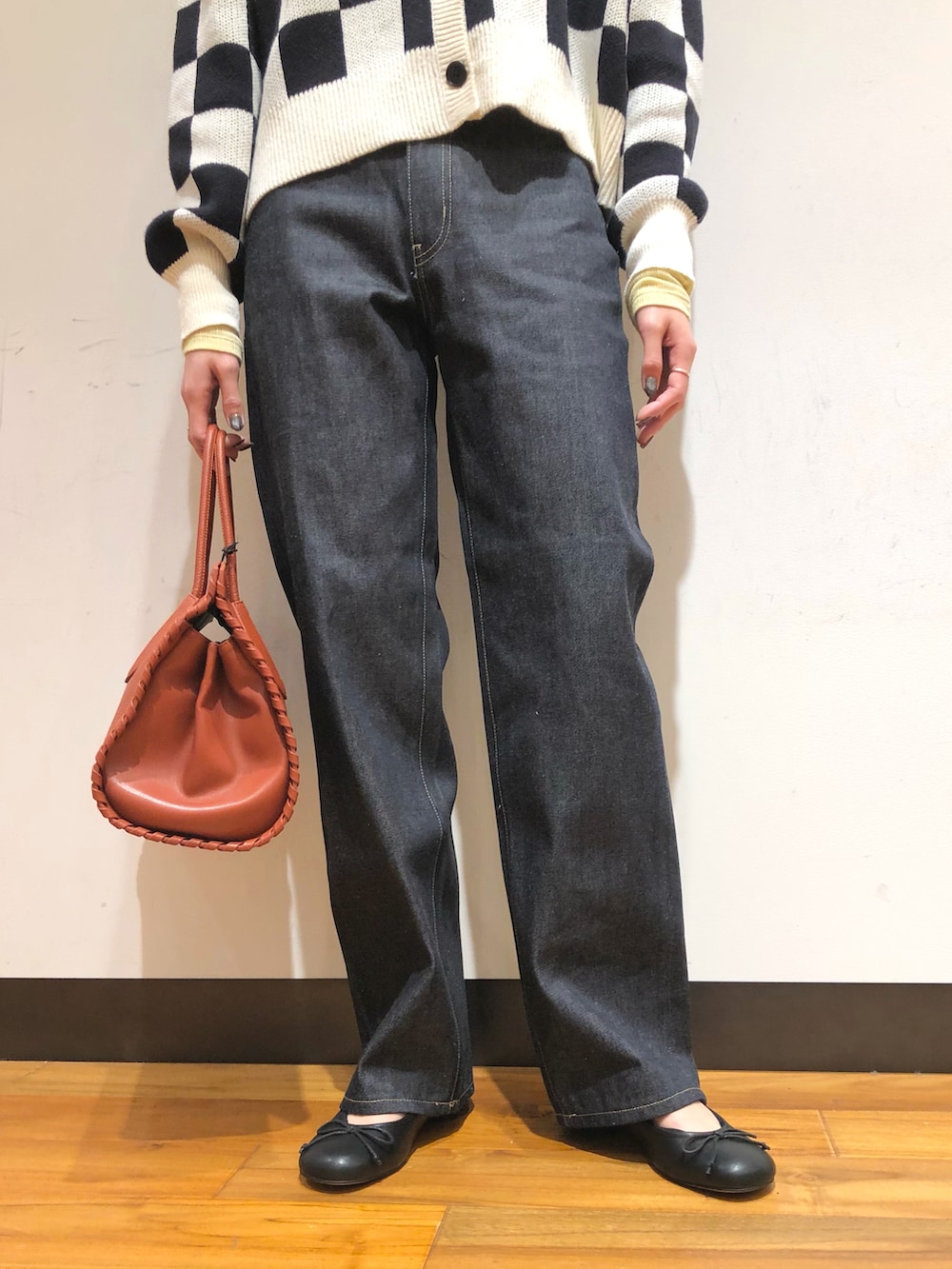 ブルー系のデニムパンツ、ブラウン系のボストンバッグ、ブラック系のバレエシューズを着用したレディースの冬コーディネートの4枚目の写真