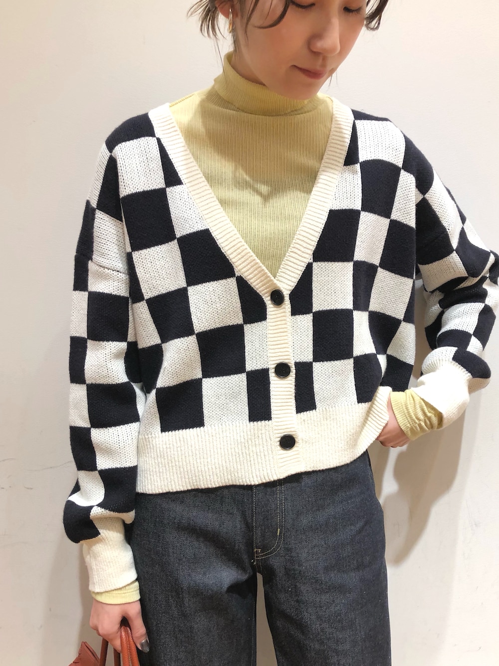 ブルー系のデニムパンツ、ブラウン系のボストンバッグ、ブラック系のバレエシューズを着用したレディースの冬コーディネートの3枚目の写真