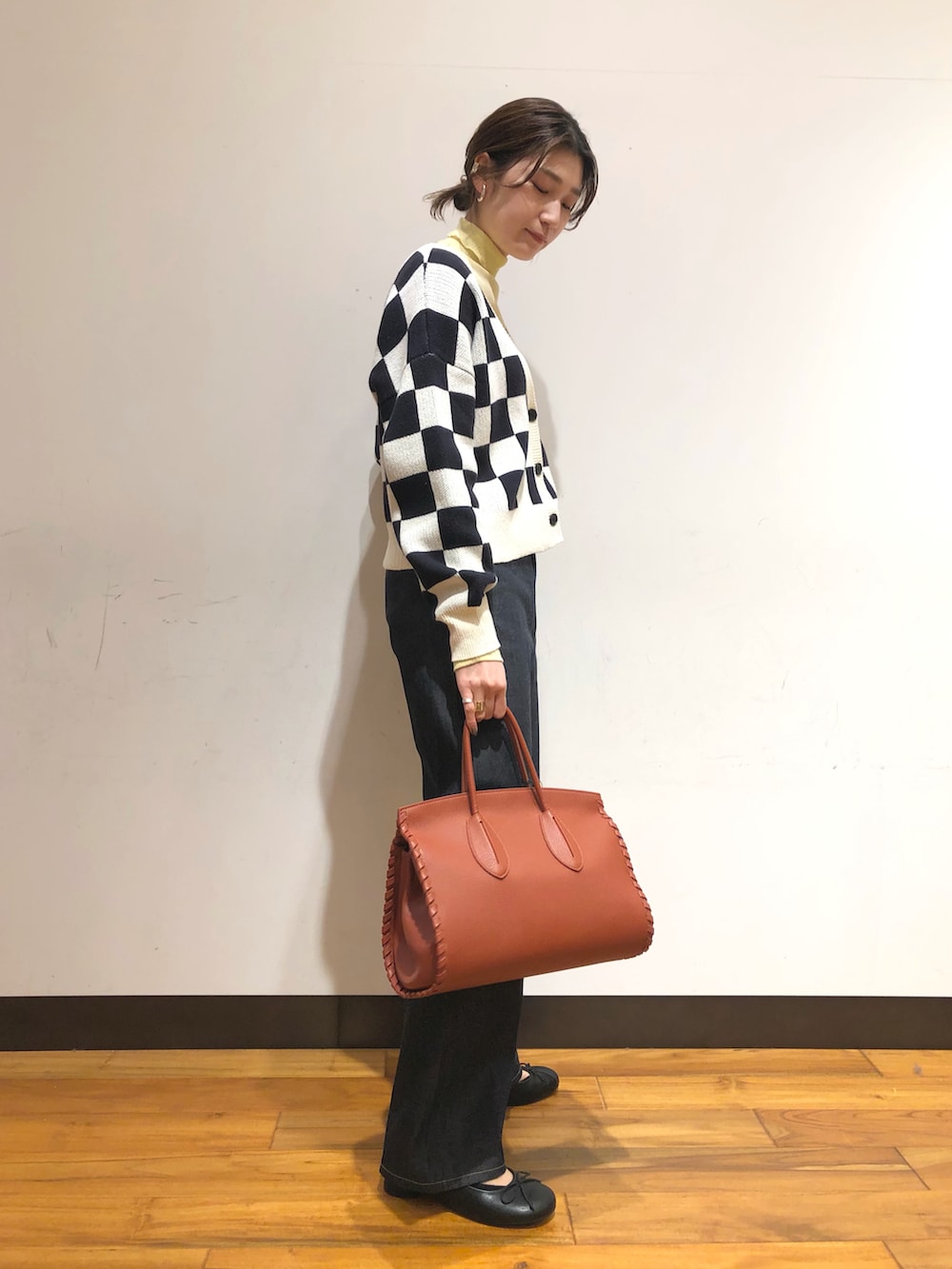 ブルー系のデニムパンツ、ブラウン系のボストンバッグ、ブラック系のバレエシューズを着用したレディースの冬コーディネートの2枚目の写真